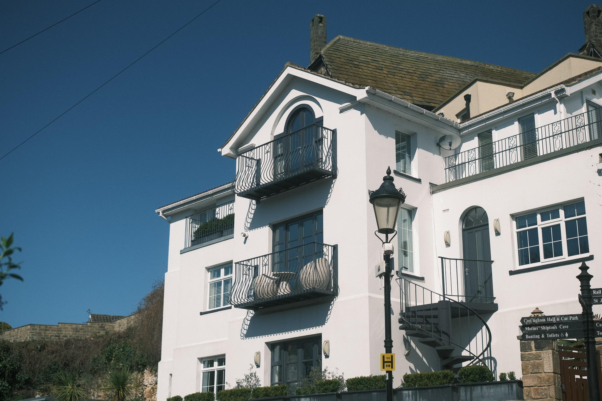 white, villaesque looking house with bright blue sky in background