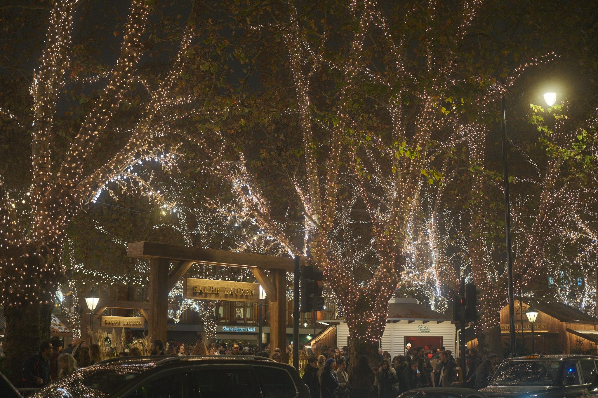 the middle of Sloane Square in London at night with Christmas lights