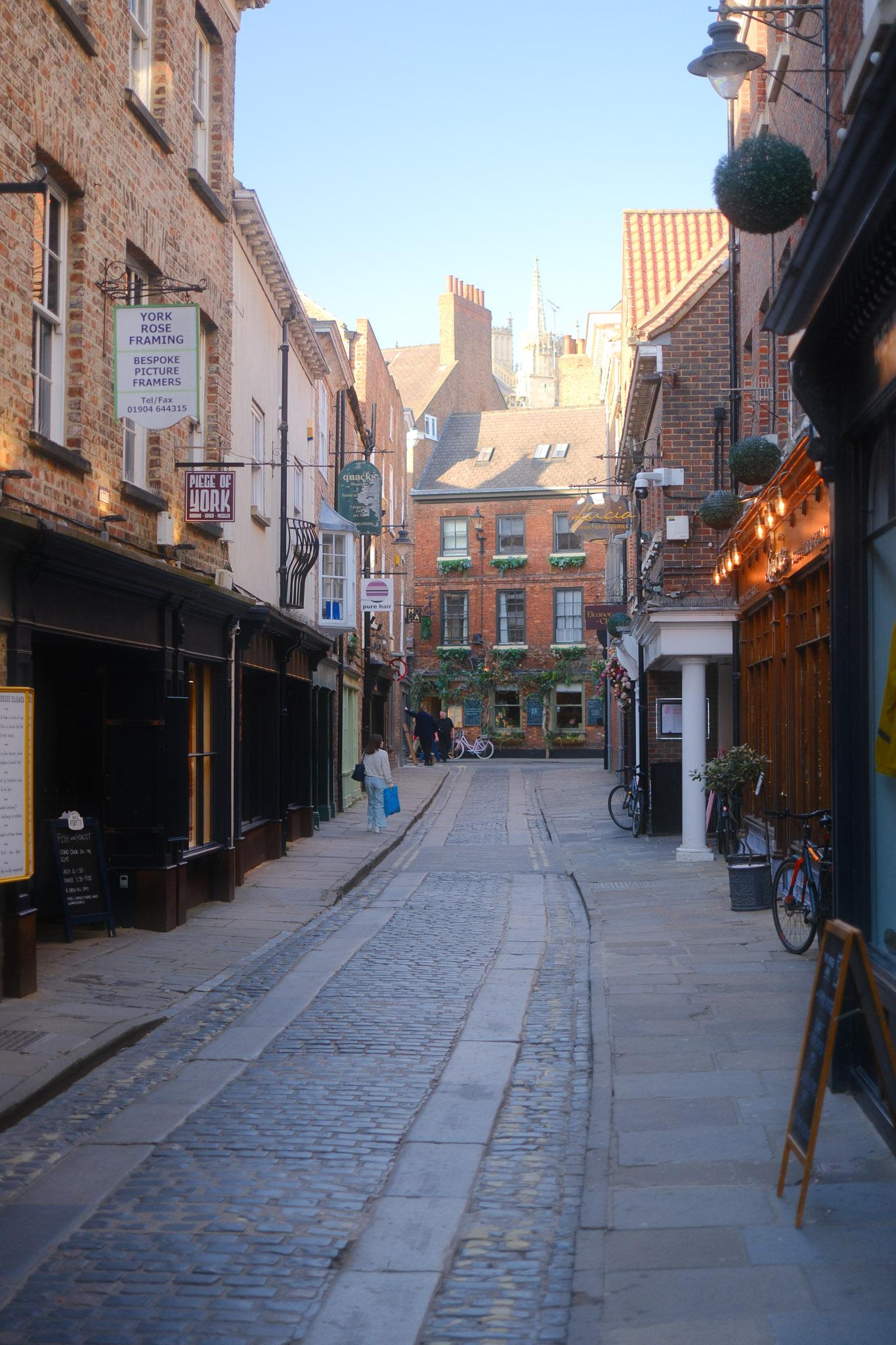 beautiful side street in York with a lady going up it